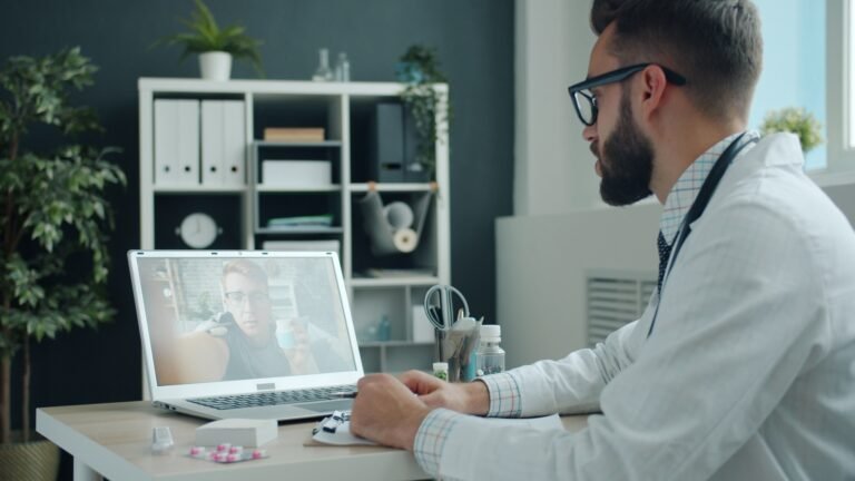 Profissional da saúde utilizando computador para organizar atendimentos no consultório.